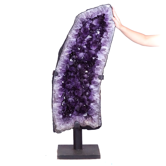 Amethyst big geode displayed on a stand with deep purple crystals.