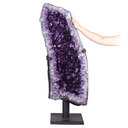 Geode crystal featuring an amethyst cave on a stand with purple crystal points.