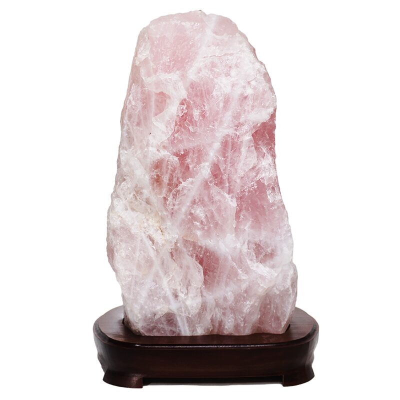 Rock lamp with rose quartz crystal mounted on dark wooden base.