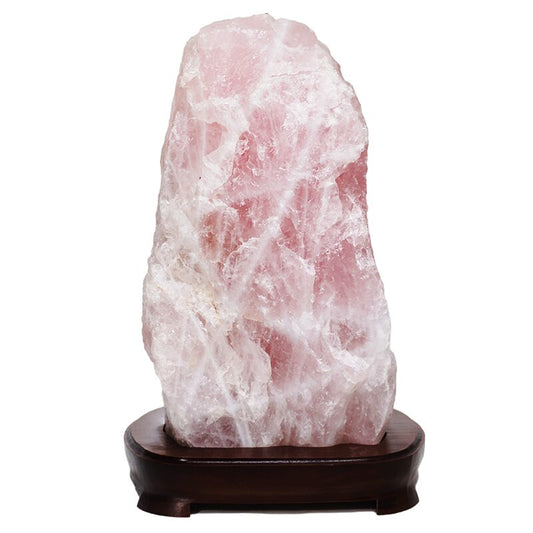 Rock lamp with rose quartz crystal mounted on dark wooden base.
