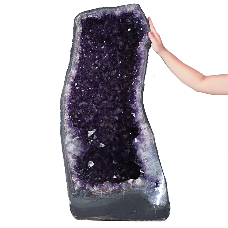 Amethyst crystal cave with deep purple points and a natural outer shell.